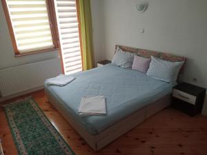 a bedroom with a large bed with blue sheets and pillows at Guesthouse Behar in Sarajevo