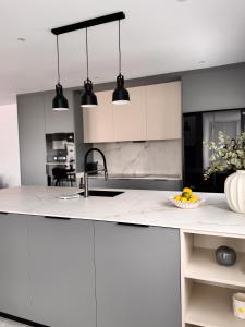 a kitchen with white cabinets and black pendant lights at Casa Benicasim in Benicàssim