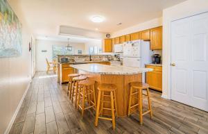a kitchen with a large island with bar stools at Casa Bella - Duck, Bayberry Bluffs, Ocean View, 500 Yds to Beach, Pool, Hot Tub, Playset, Pets OK in Duck