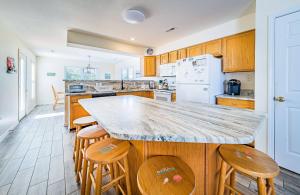 a kitchen with a marble counter top and wooden cabinets at Casa Bella - Duck, Bayberry Bluffs, Ocean View, 500 Yds to Beach, Pool, Hot Tub, Playset, Pets OK in Duck +58 photos