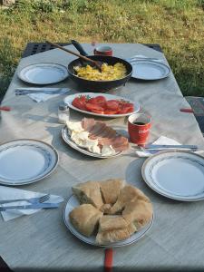 a picnic table with plates of food on it at Pine corner Mojkovac in Mojkovac