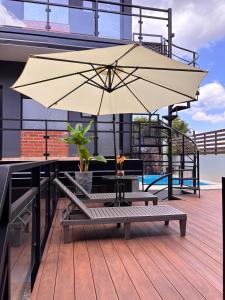 a patio with a large umbrella on a balcony at Departamentos Boutique Misiones in Puerto Iguazú