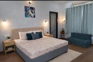 a bedroom with a large bed and a blue chair at Ellara Homes in Udaipur