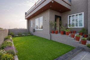 a house with a green lawn in front of it at Ellara Homes in Udaipur