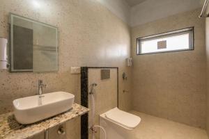 a bathroom with a sink and a toilet and a window at Ellara Homes in Udaipur +5 photos