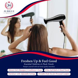 a woman drying her hair in front of a mirror at Jubilee Hotel Kensington in London