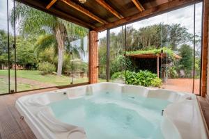 a bath tub in a room with a large window at Hotel Fazenda Vale Alvorada in Toledo