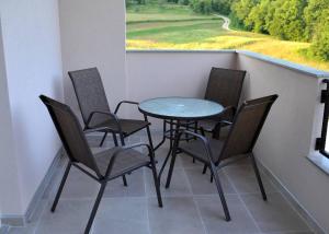 a balcony with a table and chairs and a window at Vikendica Danilo in Banja Luka