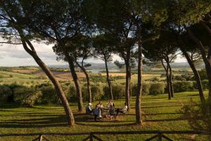 a group of people sitting on a bench in a field at Villa Cozzano in Pozzuolo