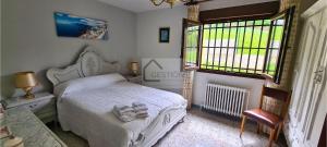 a bedroom with a white bed and two windows at Villa Teresa - Casa familiar con jardín en Cangas de Onís in Cangas de Onís