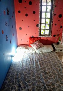 a bedroom with a large bed with a red wall at há uma bela casa in Ubatuba