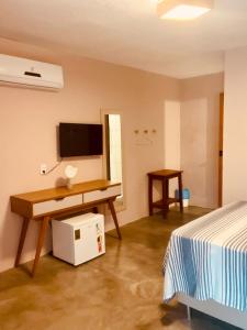 a bedroom with a desk and a tv and a bed at Villa Mar - Baia Formosa in Baía Formosa