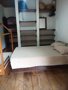 a large bed in a room with shelves at Casa Helena Barequeçaba in São Sebastião +15 photos