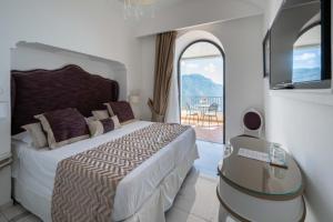 a bedroom with a large bed and a glass table at Villa Amore Amalfi Coast in Ravello
