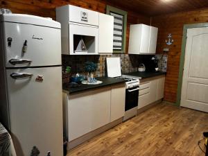 a kitchen with a white refrigerator and white cabinets at Casa B&P in Costinesti