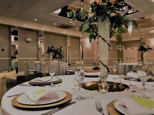 a dining room with tables with white tablecloths and flowers at The Mount Rooms in Barry