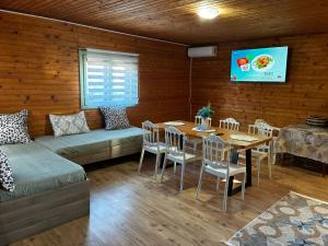 a room with a table and a couch and a table and chairs at Casa B&P in Costinesti