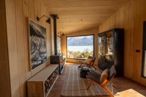 a living room with a fireplace and a large window at Moreno Camp - Glamping with a view in El Calafate