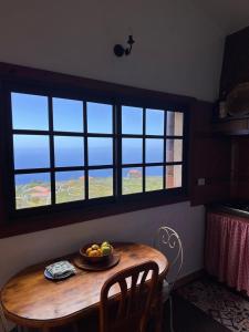 a bowl of fruit on a wooden table in a room with windows at Casa El Sato in Echedo