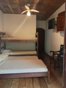 two bunk beds in a room with a ceiling fan at Casa Helena Barequeçaba in São Sebastião