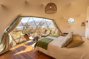 a bedroom with a bed and a large window at Moreno Camp - Glamping with a view in El Calafate