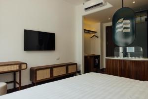 a bedroom with a bed and a flat screen tv at Lavena Boutique Hotel in Sầm Sơn