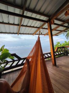 a person laying in a hammock on a deck at cabaña malambo in Termales - agua caliente - nuqui