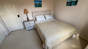 a bedroom with a bed and a nightstand with a lamp at warm house2 in Coquitlam
