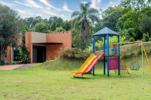a playground with a slide in a yard at Hotel Fazenda Vale Alvorada in Toledo