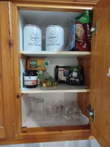 a cupboard filled with jars and other food items at Almyra traditional residence in Andros
