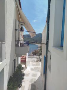 an alley between two buildings with a view of the ocean at Almyra traditional residence in Andros +34 photos
