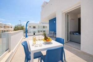 a white table with a bowl of fruit on a balcony at Scirocco Boutique Eco Hotel in Torre Pali