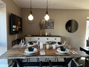 a dining room table with plates and glasses and lights at Modern & Central - Free Parking & Stylish Decor in Vossevangen