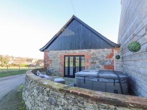 a stone wall with two trash cans in front of a building at The Steading in Dumfries