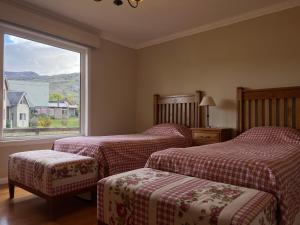 a hotel room with two beds and a window at Lo de Tomy in El Chalten