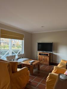 a living room with couches and a flat screen tv at Lo de Tomy in El Chalten