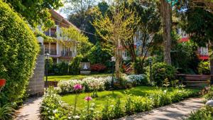 a garden in front of a building with flowers at Shikher Guest House in Kalimpong
