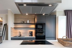 a kitchen with a black refrigerator and a sink at Reethuus Süd in Juist