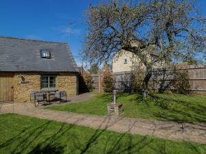 a stone house with a picnic table in a yard at The Tap Room in Kingham