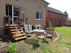 a patio with a table and chairs in a yard at Familienfreundliche Fewo mit Garten in Schwarz