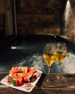 two glasses of wine and a plate of food in a hot tub at Lavena Boutique Hotel in Sầm Sơn