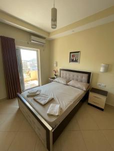 a large bed in a bedroom with a window at Honey Residence in Sarandë
