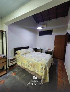 a bedroom with a bed with a yellow blanket at SUITES SANTA FÉcg A5 in Campo Grande