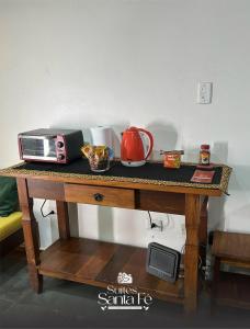 a table with a toaster and a microwave on it at SUITES SANTA FÉcg A5 in Campo Grande