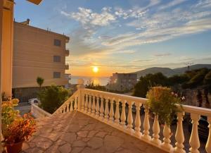 a sunset from a balcony of a building at Honey Residence in Sarandë