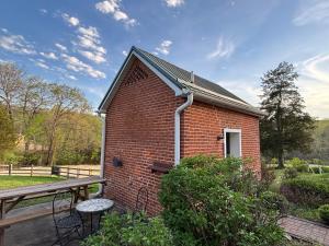 a red brick building with a porch and a bench at Hermann Crown Suites in Hermann