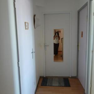 a woman taking a picture of a mirror in a hallway at chambre double dans appartement in Le Kremlin-Bicêtre