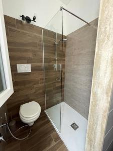 a bathroom with a toilet and a glass shower at Casa Buena Vida (locazione ad uso turistico) in Monopoli