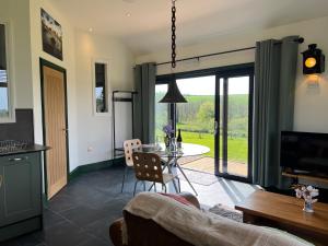 a living room with a table and chairs and a kitchen at Loom Cottage, Preseli Venture in Haverfordwest +10 photos