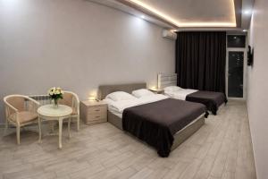 a hotel room with two beds and a table with a table sidx sidx at Wave Inn boutique in Yerevan